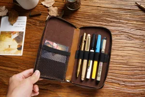 Vintage genuine leather zipper pen case detail, multi-slot stationery pouch and elastic loops.