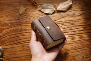 Carnet de poche en cuir marron vintage fait main detail avec bouton pression metallique.