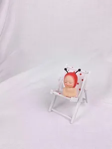 Süße Miniatur Puppen Figur auf einem kleinen weißen Holzstrandkorb Detailansicht Deko.