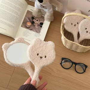 Fluffy cute bear handheld makeup mirror with soft plush fabric and lovely facial embroidery.