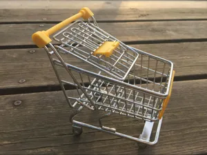 Detail van mini metalen winkelwagentje, bureau opbergmandje en leuke decoratie prop.