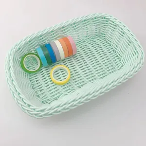 Vue détaillée d'un panier de rangement en plastique vert menthe avec des rubans colorés.