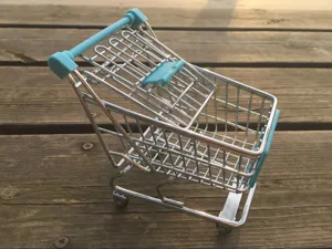Mini metalen winkelwagen detailoverzicht, blauwe handgreep draadmand bureau decoratie prop.