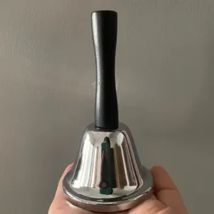 Campana de mano de metal con mango de madera, timbre escolar o zumbador de juego.