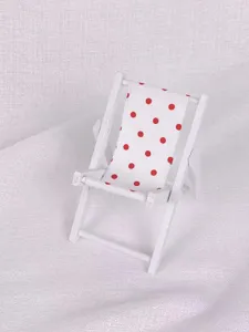 Detailansicht eines dekorativen Miniatur-Holzstrandstuhls mit rotem Polka-Dot-Muster.