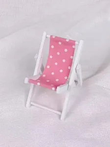 Rosa gepunkteter kleiner Strandstuhl aus Holz als Handyhalter und Tischdekoration.