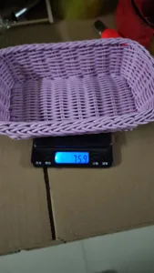 Gros plan d'un panier de rangement en plastique tisse violet clair sur une balance de detail.