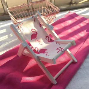 Nahaufnahme des Mini-Holzstrandstuhls mit süßem rosa Flamingo-Stoffmuster für Dekor.