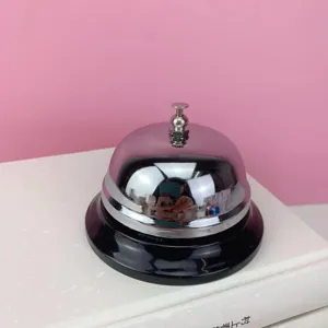 Primer plano detallado del timbre de servicio de metal sobre libro con cúpula cromada.