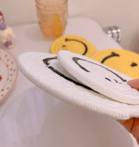 Cute cotton woven coaster with smiley face design, handmade aesthetic table mat for cups.