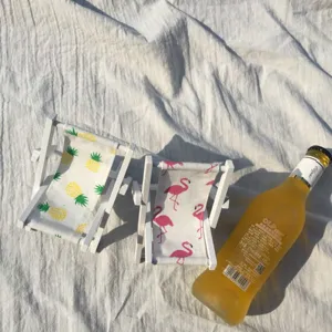 Nahaufnahme von Mini-Holzstrandstühlen mit süßen Ananas- und Flamingostoffmustern.