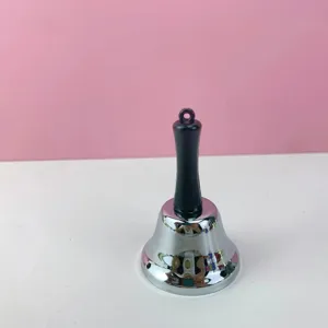 Vista detallada de campana de mano de metal, acabado plateado claro y mango negro para juegos.