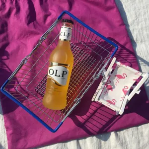 Rosa Flamingo Muster Holz Strandkorb Handyhalter mit Cocktailflasche als Deko Requisite.