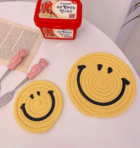 Cute cartoon smiley face woven cotton coaster, heat-resistant table mat for daily home decor.