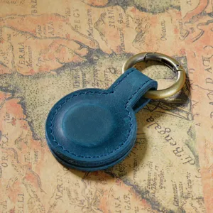 Dettaglio in primo piano della clip magnetica in pelle blu, accessorio per zaino e supporto.