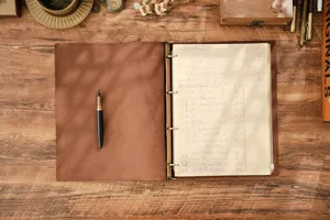 Vista di dettaglio del taccuino ad anelli in vera pelle vintage con carta retro e penna.