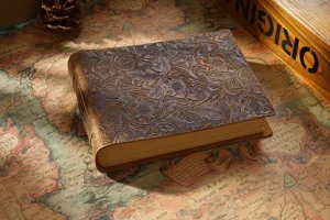 Vintage embossed genuine leather notebook, retro floral sketch journal detail view.
