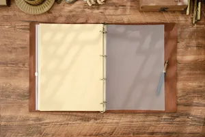 Primo piano di un taccuino vintage in pelle con foglio divisorio opachi e anelli.