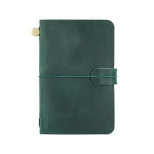 Cuaderno de viaje vintage de cuero verde oscuro con cubierta artesanal y banda elástica.