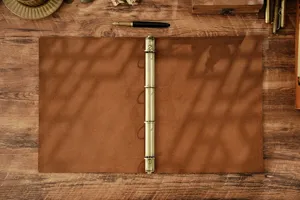 Vista dettagliata di un quaderno raccoglitore A4 in vera pelle vintage su scrivania in legno.
