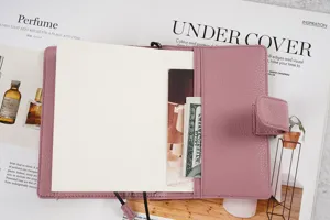 Echtleder A6 Planerhülle in mauve Litchi-Muster mit Druckknopfverschluss und Innentaschen.