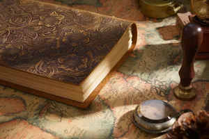 Close-up detail of vintage embossed leather journal notebook cover with floral pattern and warm lighting.