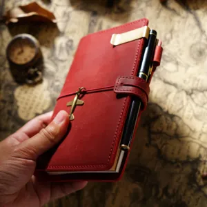Vintage Leder Tagebuch mit Flugzeug Anhänger und Stift, rotes tragbares Notizbuch.