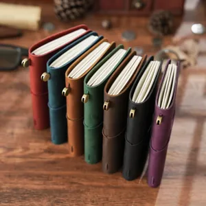 Cuaderno de viaje de cuero vintage con banda elastica y cierre metalico en varios colores.