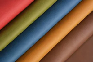 Rollos de cuero multicolor que muestran varios colores y texturas para cuadernos y manualidades.