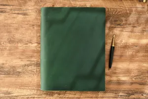 Vista dettagliata del taccuino in vera pelle vintage con penna stilografica.