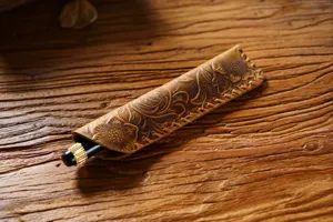 Vintage genuine leather pen sleeve detail showing handmade embossed floral pattern.