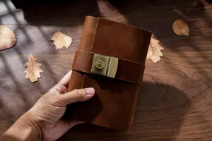 Handmade vintage genuine leather A6 notebook detail showing brass combination lock and texture.