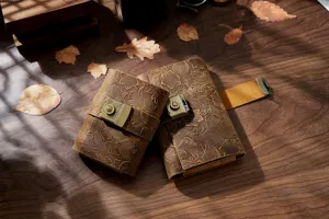 Detailed shot of vintage embossed leather journals with metal lock on rustic wooden table.