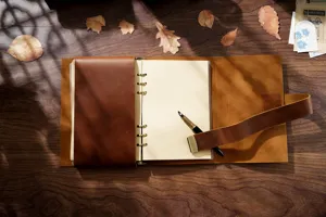 Vista detallada del cuaderno de anillas de cuero retro con textura y anillas metálicas.