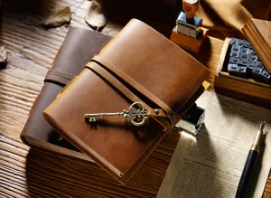 Dettaglio del taccuino da viaggio vintage in pelle con chiave in metallo e cinturino.