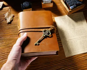 Taccuino vintage in vera pelle con chiave in ottone e chiusura a cinturino per scrittura quotidiana.