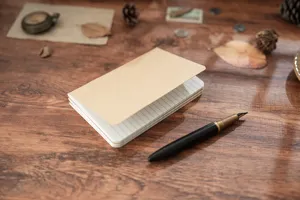 Vue détaillée d'une recharge de carnet en papier kraft ligné sur un bureau en bois rétro.