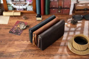 Nahaufnahme des echten Leder Reissverschluss Notizbuch Etuis auf Holztisch mit Requisiten.