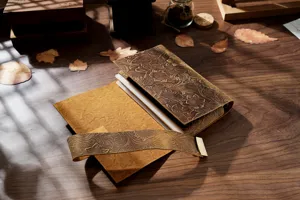 Vintage embossed genuine leather A6 notebook detail, floral carved texture with metal lock.
