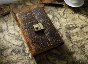 Nahaufnahme des Vintage Lederjournals mit geprägtem Blumenmuster und Antikschloss.