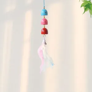 Close-up of colorful cartoon bell pendant with mini bells and soft feathers for decoration.