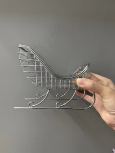 Gedetailleerd aanzicht van mini zilveren ijzeren kerstslee decor, draadgaasontwerp, feestelijk rekwisiet.