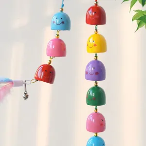Colorful metal bell wind chime pendant with cute smiling face paint for DIY crafts and home decor.