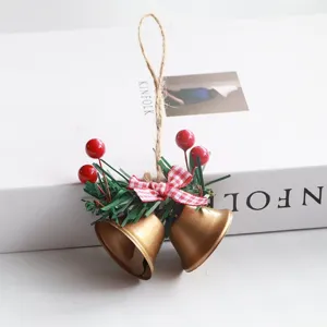 Close-up of Christmas bells decoration with pine needles and plaid bow for tree hanging.