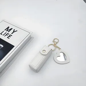 White leather lipstick holder keychain with cute heart mirror pendant for daily use.