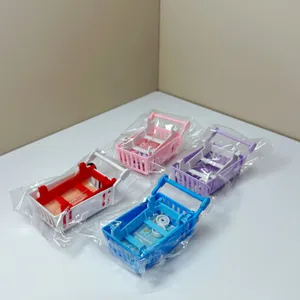 Mini shopping cart toy detail view, four colorful plastic supermarket trolley props.