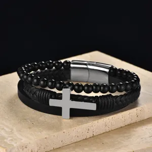 Detailed close-up of multi-layer men's leather bracelet with silver stainless steel cross