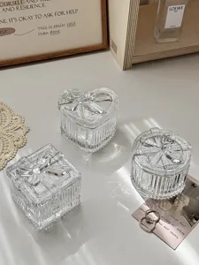 Nahaufnahme von klaren Glasaufbewahrungsboxen mit Schleifendeckeln für filigranen Schmuck.