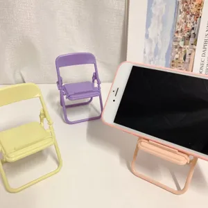 Close-up detail of cute pastel mini folding chair phone stand showing compact desktop decor design.