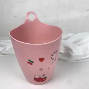 Primo piano del secchio di stoccaggio sospeso rosa con simpatici coniglietti e pratico foro.